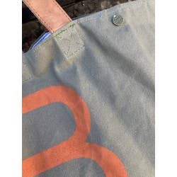 NR81 tote-taske i lærred – detalje af hank, logo og orange print