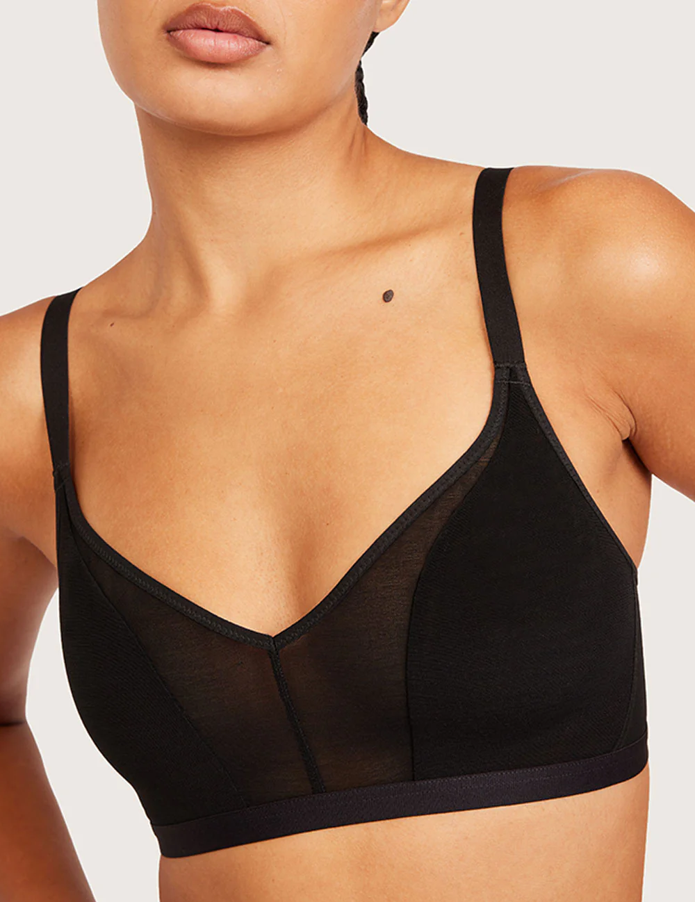 Detalje af V-udskæring og mesh på Boody FreeMesh Crop BH i sort